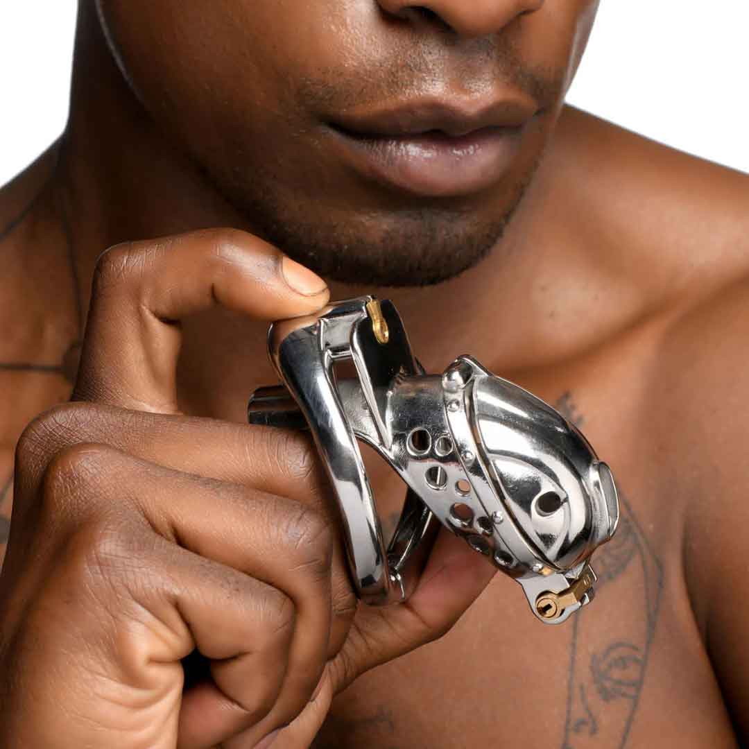 man curious about trying self chastity with a chrome metal chastity cage in his hand<br />
